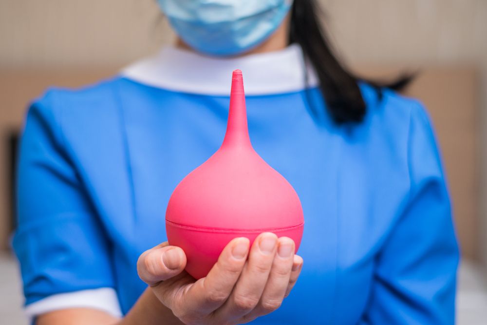 Клизма-груша в руке медсестры.